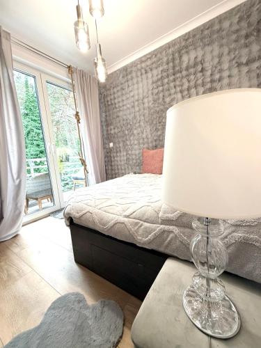 a bedroom with a bed and a lamp on a table at Pokład Jurata in Jurata
