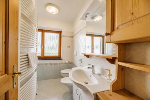 a bathroom with a white sink and a toilet at Appartamenti Cèsa Sorèie by AMA Val di Fassa in Canazei