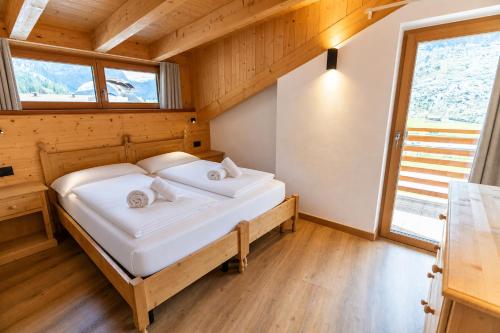 a bedroom with a bed in a wooden room at Appartamenti Cèsa Sorèie by AMA Val di Fassa in Canazei
