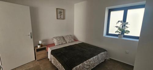 a small bedroom with a bed and a window at L'escalade Lyon Aéroport in Janneyrias