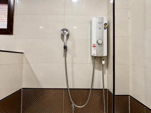 a shower with a hose attached to a wall at Aruna Mountain Lodge in Ban Huai Rin