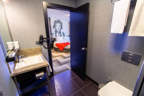 a bathroom with a sink and a room with a bed at Maltepe 2000 Hotel in Ankara