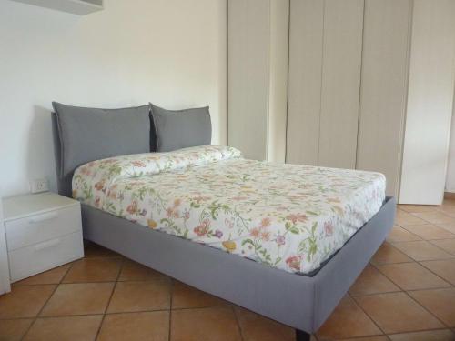 a bed with a floral comforter in a bedroom at BlueVille21 in Germignaga
