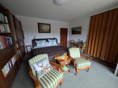 a bedroom with a bed and two chairs at Haus Kiel Wohnung Wolfswarte in Altenau