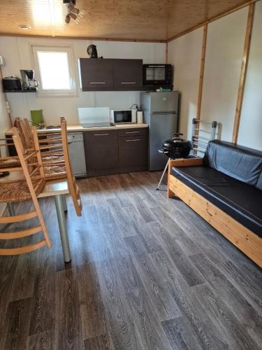 a room with a couch and a table and a kitchen at Escapade Calme &Nature in Sulniac