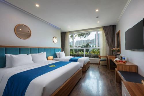 a hotel room with two beds and a television at Oriana Hotel in Hanoi
