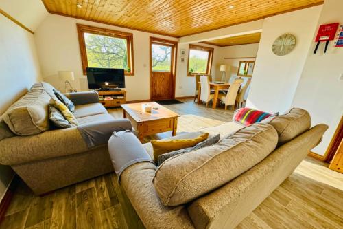 a living room with a couch and a table at Lazy Bear Lodge with Hot Tub - Finlake Resort and Spa in Devon in Chudleigh
