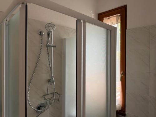 a shower in a bathroom next to a glass door at Albergo Legazzuolo Montecampione in Artogne