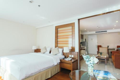 a bedroom with a bed and a living room at Thomson Residence Hotel in Bangkok