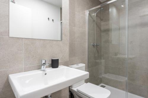 a bathroom with a toilet and a sink and a shower at Live It Malaga in Málaga
