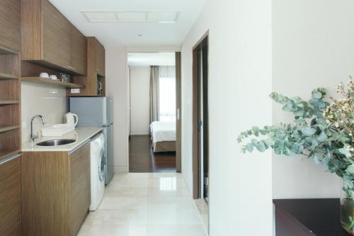 a kitchen with a sink and a refrigerator at Thomson Residence Hotel in Bangkok