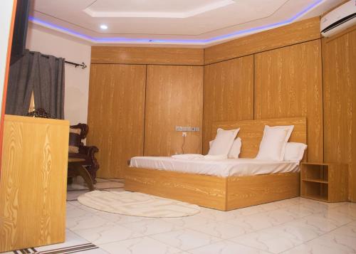 a bedroom with a bed with a wooden wall at Hotel St Flavien Lomé in Taméklo