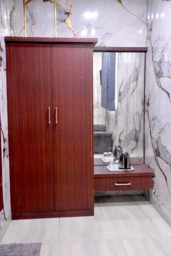 a wooden cabinet in a bathroom with a sink at Queen Palace in Mathura