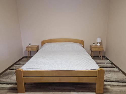a bed in a room with two nightstands and two tables at Seosko domaćinstvo Rada in Papratište