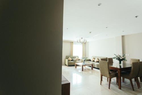 a living room with a table and chairs and a couch at Thomson Residence Hotel in Bangkok