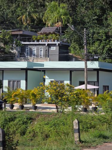 a building with trees and flowers in front of it at Tiffany Villa 2 in Ko Phangan