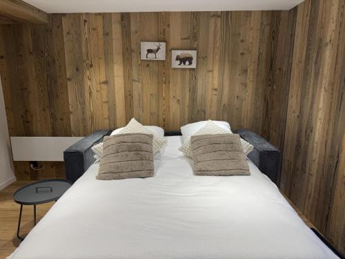 a bedroom with a large white bed with two pillows at Studio alpin au centre de la station in Saas-Fee