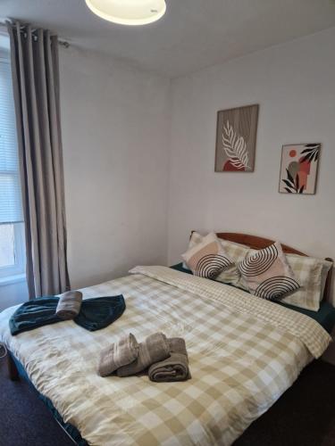 a bedroom with a bed with two pairs of shoes on it at Boho Bliss in Swansea