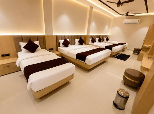 ein Schlafzimmer mit drei Betten in einem Zimmer in der Unterkunft Hotel Mewada in Ujjain