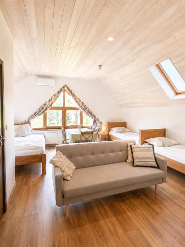 a living room with a couch and two beds at Danielówka in Ciemiętniki