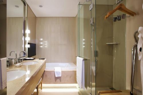 a bathroom with a tub and two sinks and a shower at Hotel Entra Gangnam in Seoul