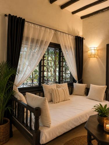 a large bed in a room with a window at Saffron Garden Malindi in Malindi