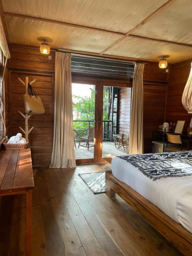 a bedroom with a large bed and a balcony at The Tropical Koh Mook in Ko Mook