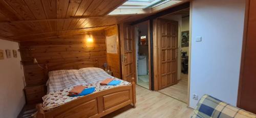 a bedroom with a bed in a room with wooden walls at Apartament nad Jeziorem Necko in Augustów