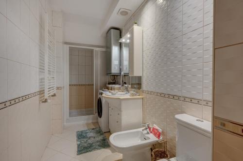 a bathroom with a toilet and a sink at Cozy Apartment Floreasca Park in Bucharest