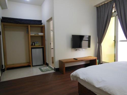 花蓮市にあるShi Mom B&Bのベッドと薄型テレビのある寝室