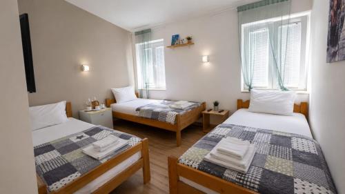 a room with two beds and two windows at Serenita Stone House in Bečići
