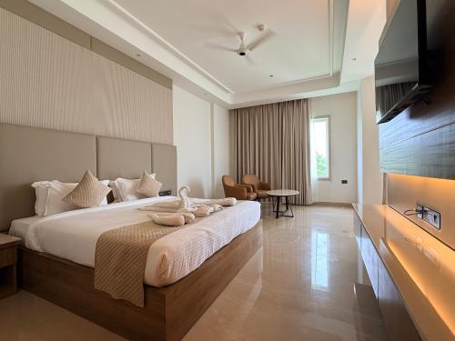 a hotel room with a large bed and a table at Bhola Resort in Soraon