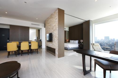 a hotel room with a dining table and a bedroom at Hotel Entra Gangnam in Seoul