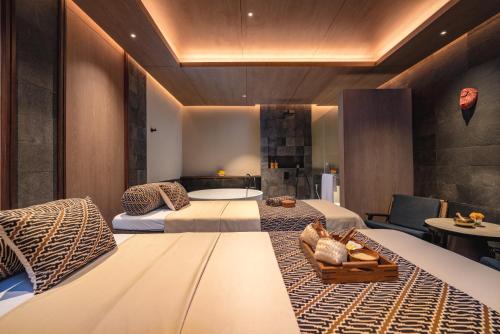 a hotel room with two beds and a table at Nuju Uluwatu - Adults Only in Uluwatu