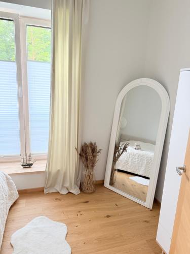 a mirror in a room with a bed and a window at Liiva apartement Kärdla in Kärdla
