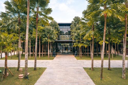 a building with palm trees in front of it at ONYX PARK RESORT Ubud in Ubud