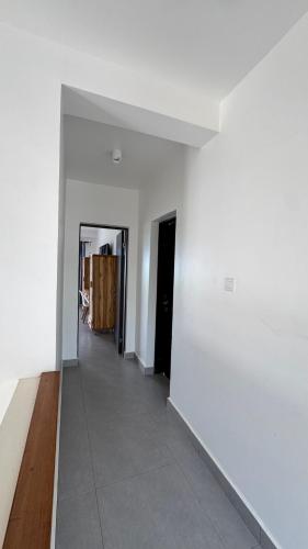 an empty room with a white wall and a hallway at ZanziBlue Beach Hotel in Mfumbwi