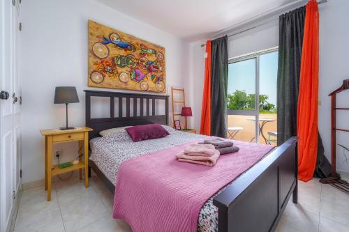 a bedroom with a bed with a pink blanket at See view Mignon de la Ria Formosa in Faro
