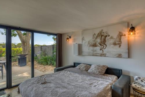 a bedroom with a bed and a large window at Mas Des Jeux - Gîte Grenache in Saint-Laurent-dʼAigouze