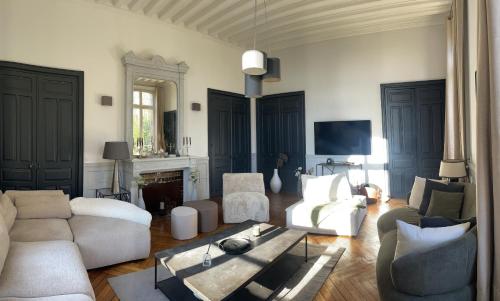 a living room with white furniture and a fireplace at Les Thibériades in Martin-Église