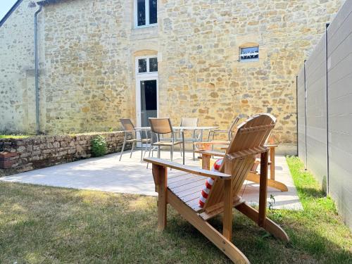 a patio with chairs and a table in front of a building at Le 449 - Collection La 21ème Planche in Bayeux