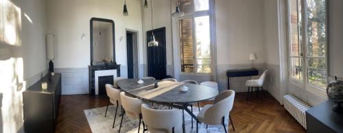a dining room with a table and white chairs at Les Thibériades in Martin-Église
