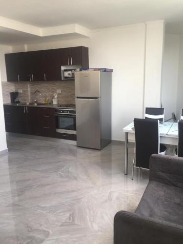 a kitchen with a refrigerator and a table with chairs at Dizengoff 24A in Netanya