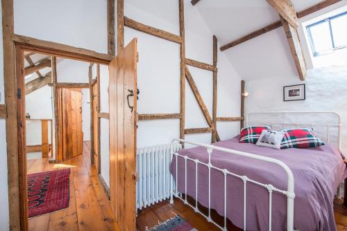 a bedroom with a bed in a room with wooden beams at Melin Abereiddy in Haverfordwest