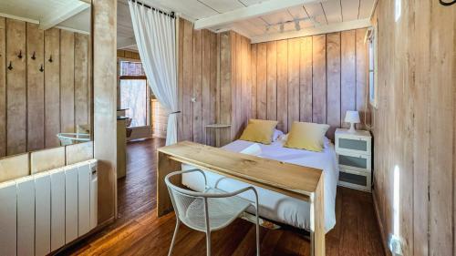 a bedroom with a bed and a wooden wall at Cabaña Le Sapin in Osséja