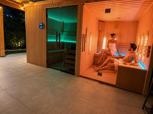 a couple of people sitting in a sauna at VILLA DORA - CENTRUM,BASEN PODGRZEWANY,JACUZZI SAUNA, Plac zabaw, Parking in Mielno