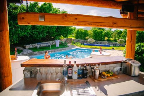 a backyard swimming pool with a kitchen and a sink at Lika Story in Josipdol