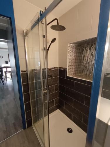 a bathroom with a shower with a glass door at Le Nid d'Ouilly in Pont-d'Ouilly