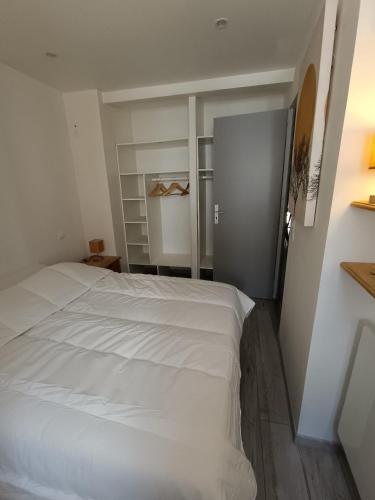a bedroom with a white bed and a closet at Le Nid d'Ouilly in Pont-d'Ouilly