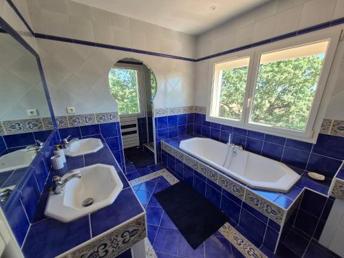 a blue and white bathroom with a tub and a sink at Montèze Paradis in Saint-Christol-lès-Alès